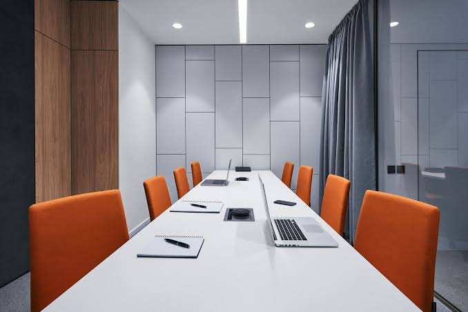 Conference room with white painted walls, decorative wall panels, and wood finishes by a professional painter in Downingtown, PA.